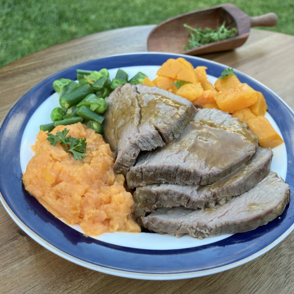 Roast beef meal with gravey, pumpkin, mashed sweet potato, peas and beans