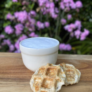 Treat-size Wuffles and a puppacino on a wooden board in a garden